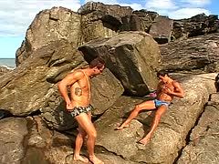 Sportliche Männer treiben es am Strand